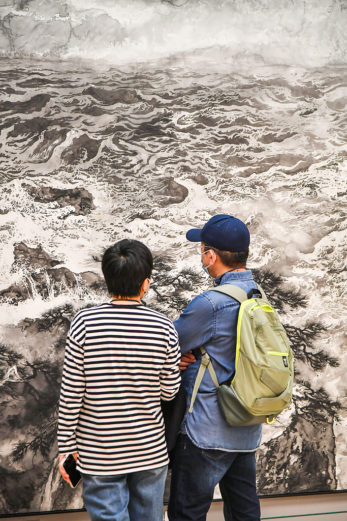 A photo taken on October 13, 2024 shows visitors appreciating an artwork on display at the National Art Museum of China in Beijing. /CFP