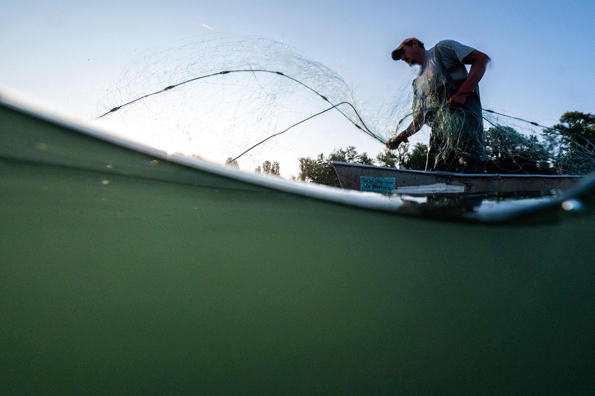 A French fisherman controls a fishing net on the canalised section of the Rhine River in Ottmarsheim, eastern France, June 9, 2023. /CFP