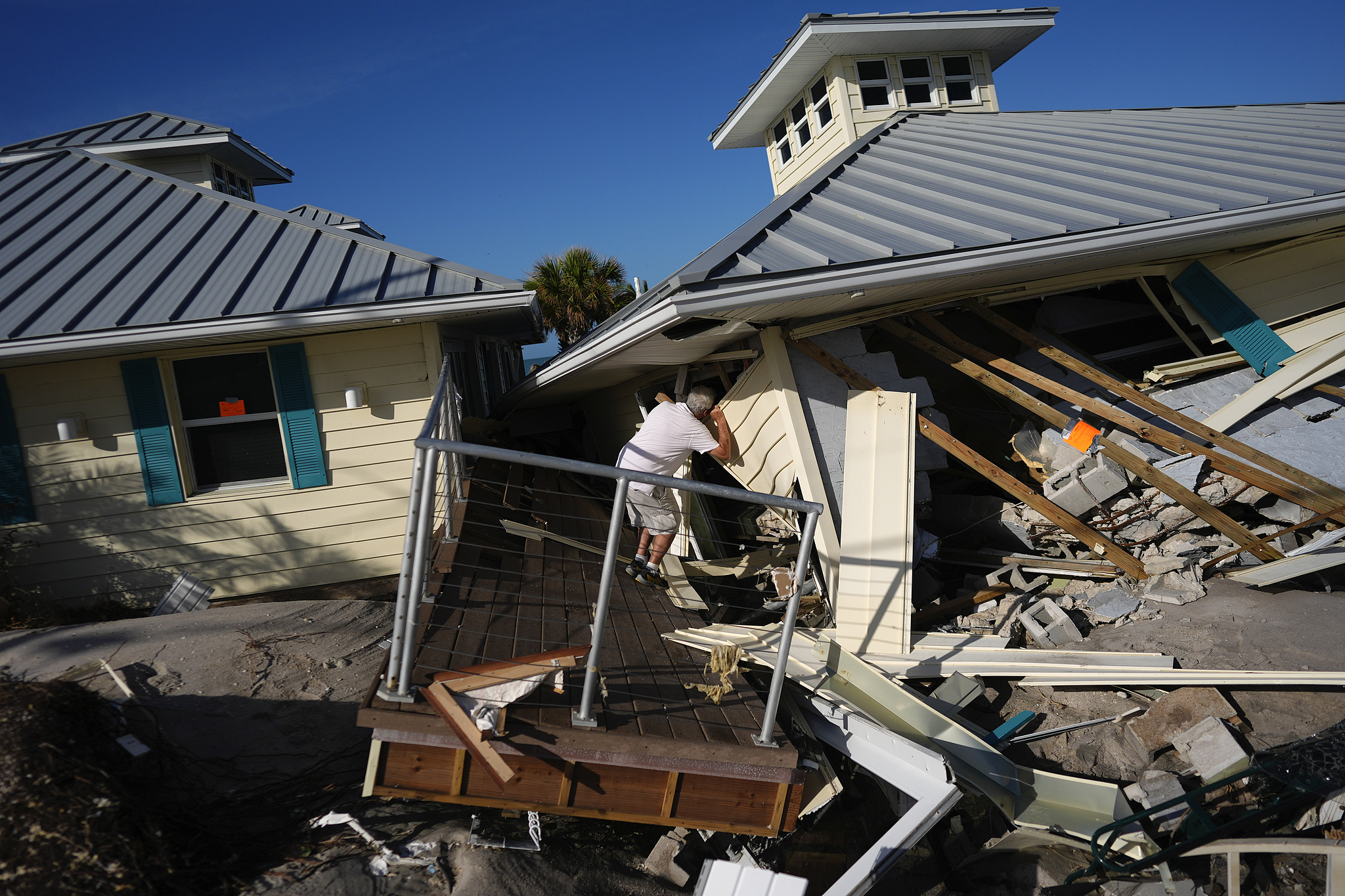 A property owner peers into the remains of the second floor unit where he lived with his wife while renting out the other units, on Manasota Key, in Englewood, Florida, following the passage of Hurricane Milton, October 13, 2024. /CFP