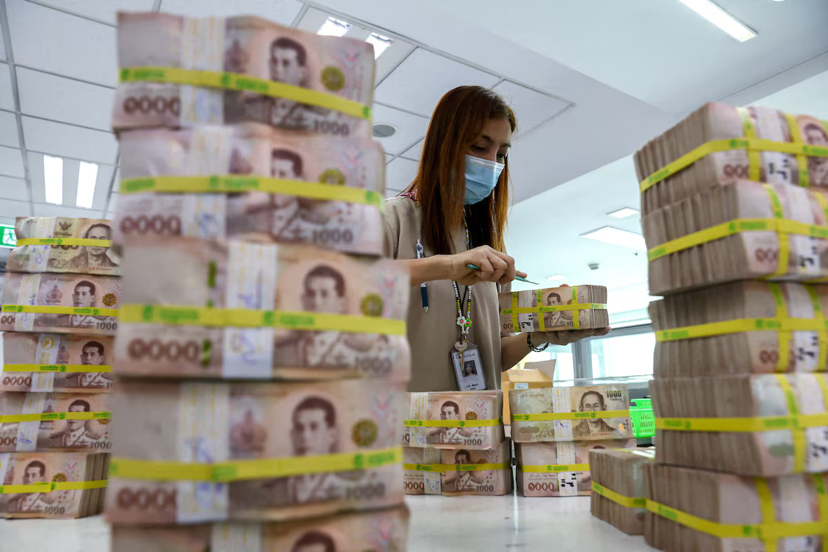 A bank employee gathers Thai baht notes at a Kasikornbank in Bangkok, Thailand, January 26, 2023. /Reuters