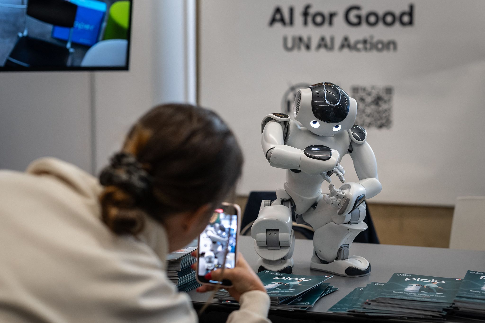 A participant takes photos of an autonomous, programmable humanoid robot at the AI for Good Global Summit in Geneva, July 5, 2023. /CFP