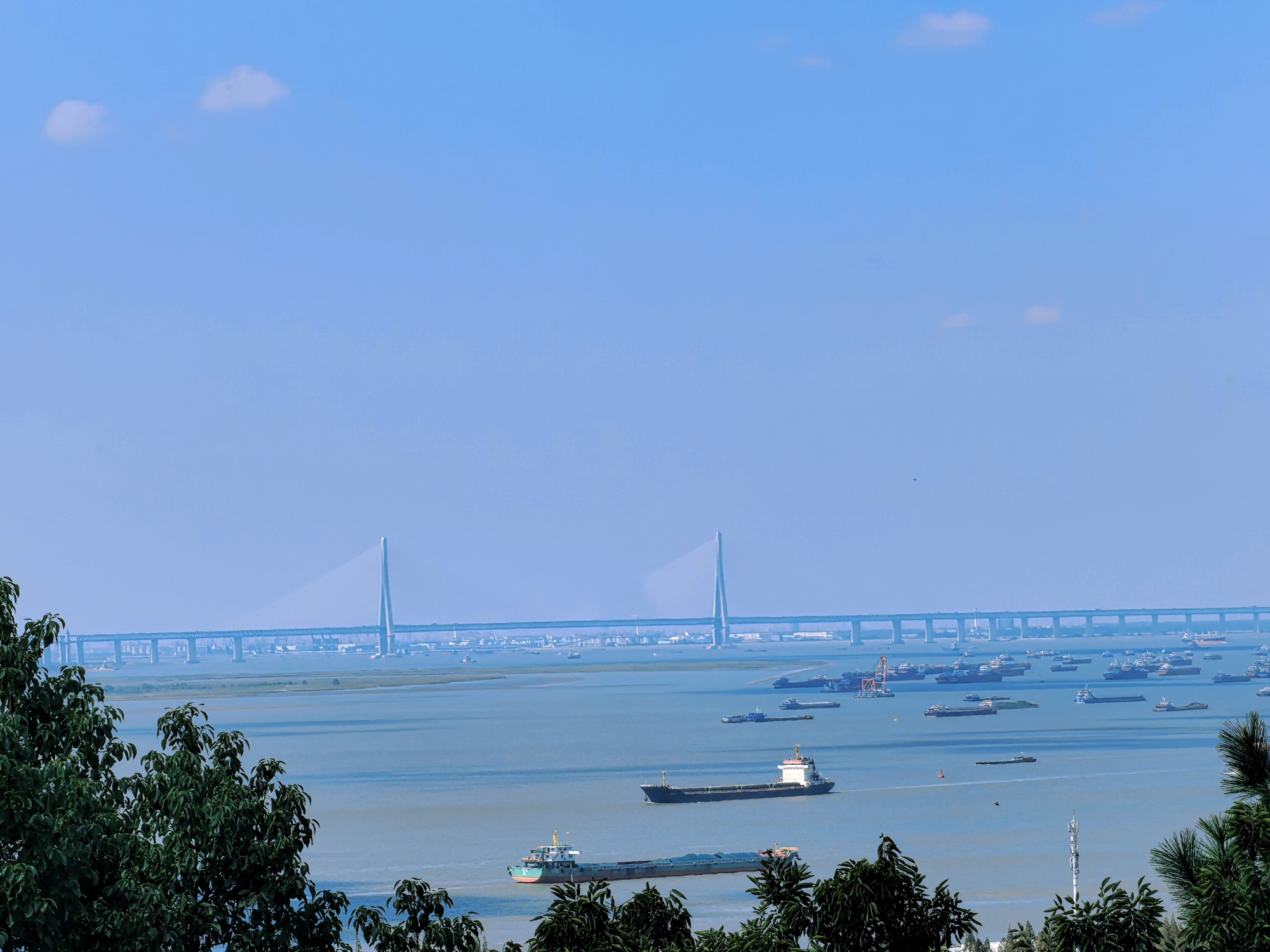 Cargo ships run on the Yangtze River next to Langshan, or Wolf Hill, in Nantong, east China's Jiangsu Province, on October 3, 2024. /CGTN