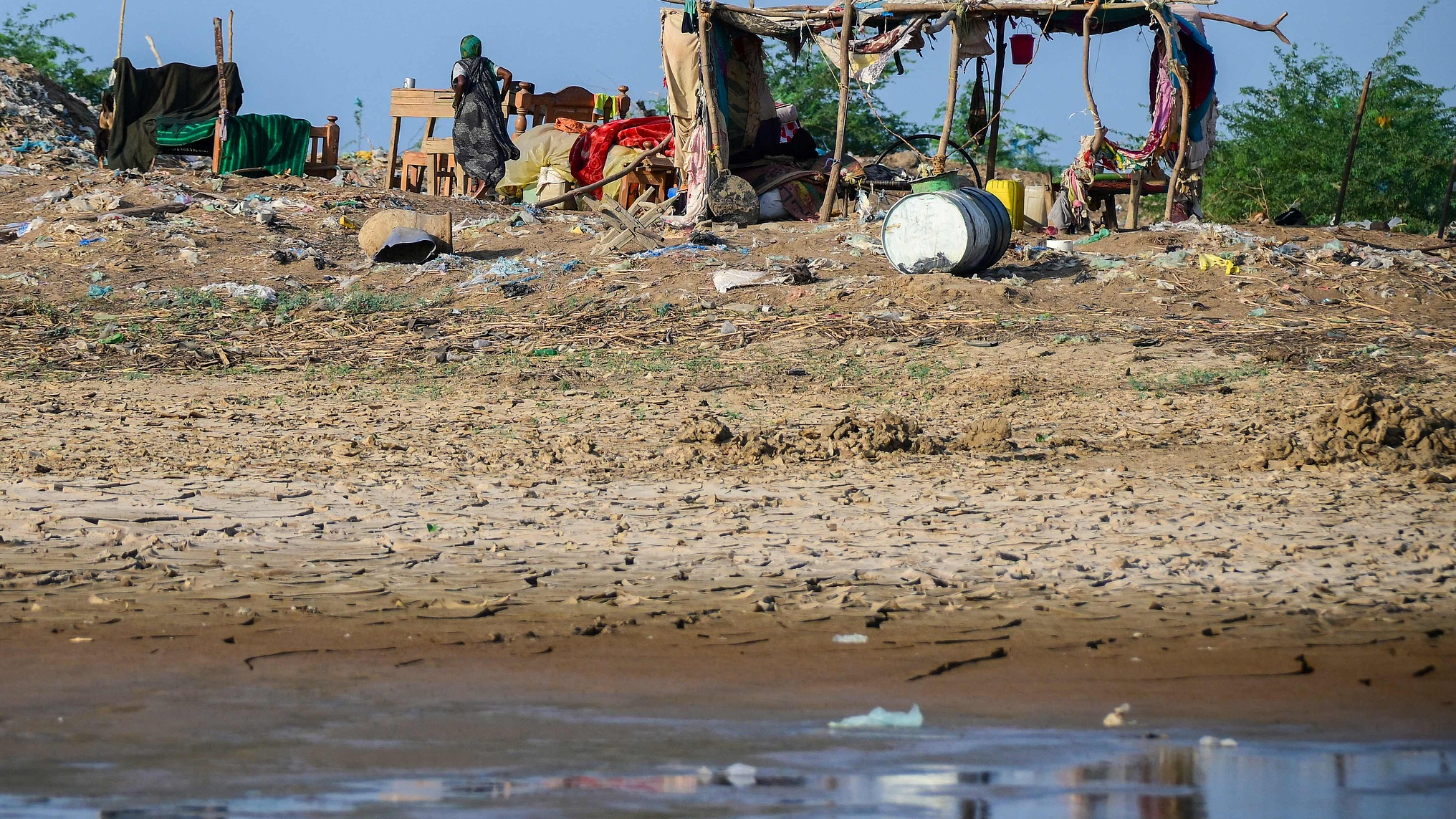 A Sudanese woman walks near a makeshift shelter in Tokar in the Red Sea State following recent heavy flooding in eastern Sudan, October 3, 2024. /CFP