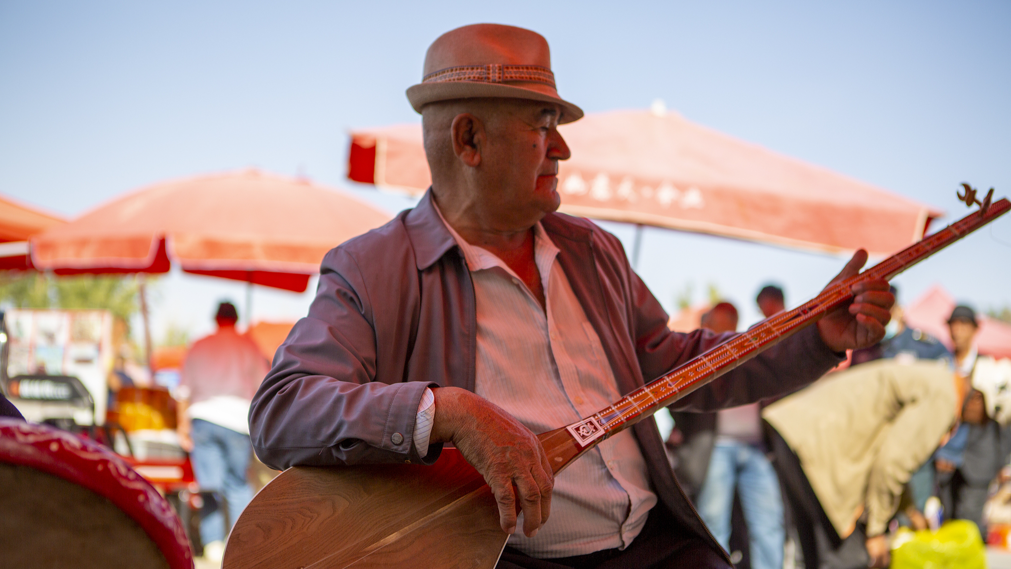 A local resident performs on a musical instrument in Aksu Prefecture, northwest China's Xinjiang Uygur Autonomous Region, October 13, 2024. /CFP