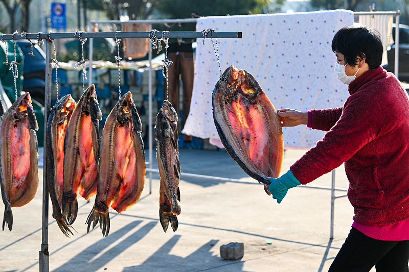 A file photo shows a villager hanging fish out to dry in a yard in Suzhou City, Jiangsu Province. /CFP