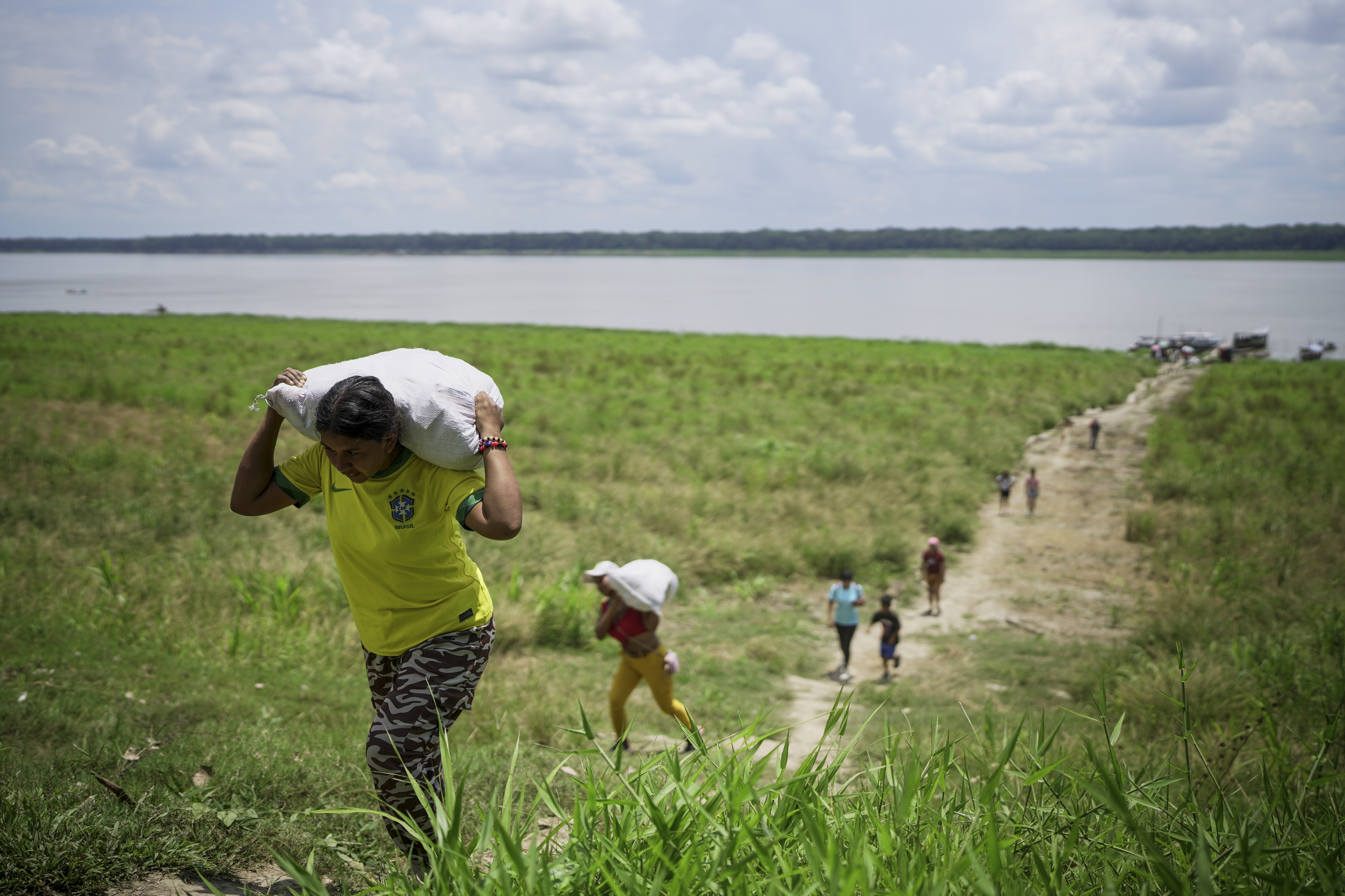 People from the Tikuna Indigenous community carry aid from a nonprofit amid a drought on Amazon River in Loma Linda, near Leticia, Colombia, October 20, 2024. /AP