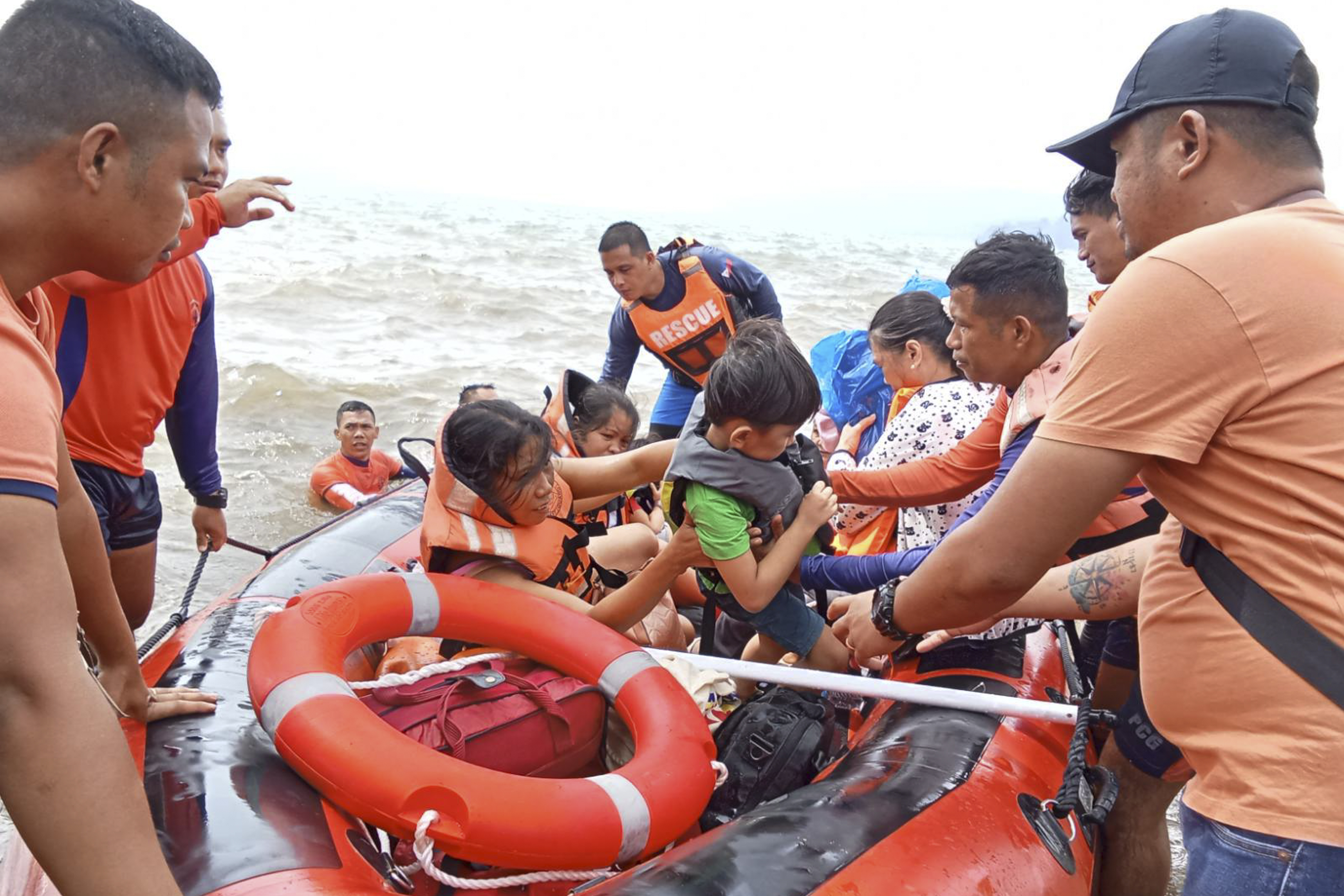 In this photo provided by the Philippine Coast Guard, residents alight a rubber boat after being ferried to safer grounds in Batangas province, the Philippines, October 25, 2024. /AP