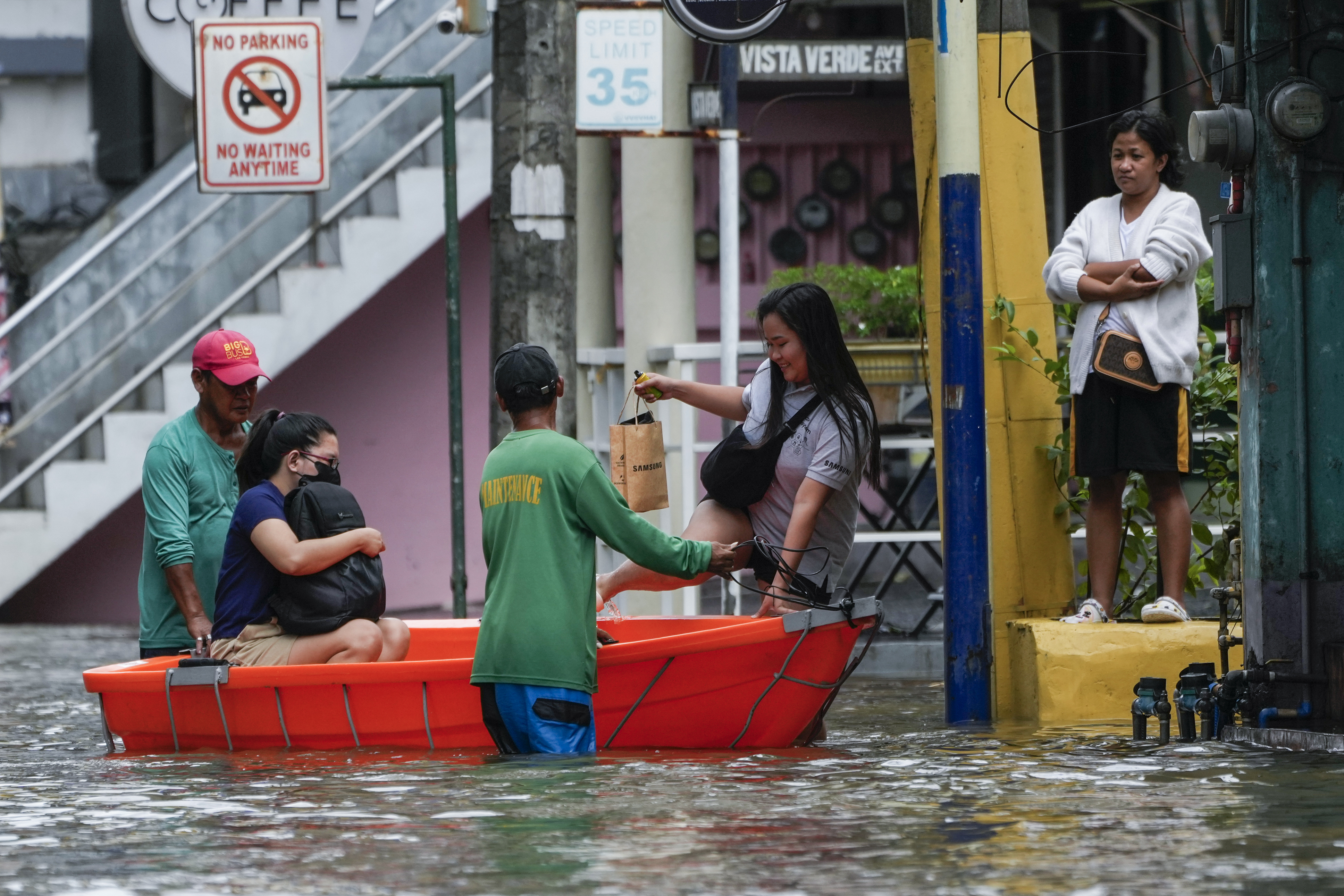 Residents use a boat to cross flooded streets caused by Tropical Storm Trami in Cainta, Rizal province, the Philippines, October 25, 2024. /AP