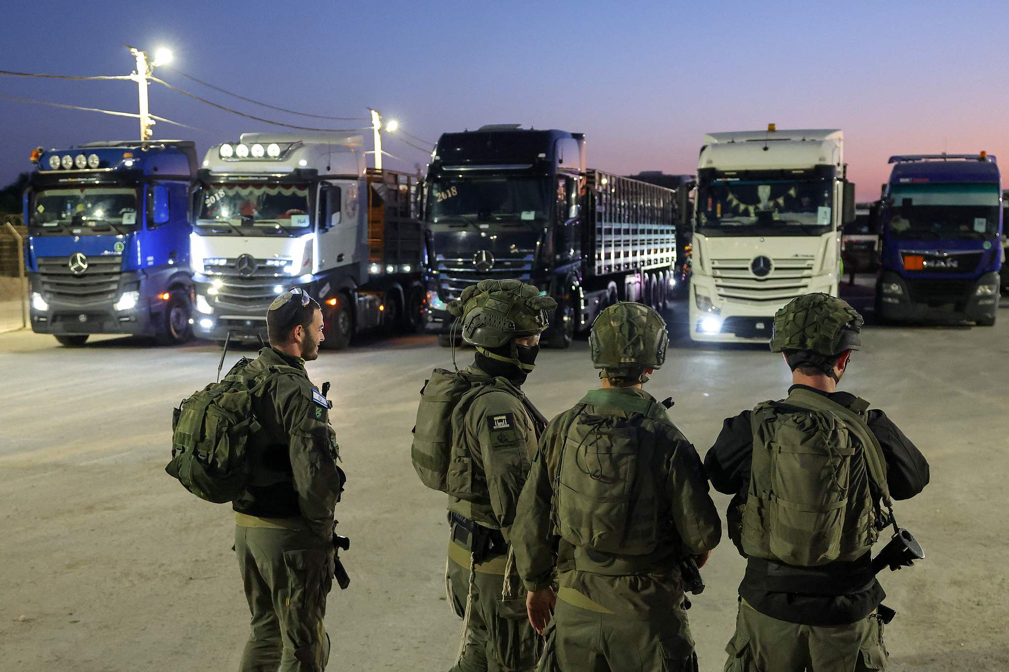 Israeli soldiers stand guard as trucks loaded with humanitarian aid delivered from Jordan wait to cross into Gaza on the border between Israel and the northern Gaza Strip, through the Israeli-controlled Erez Crossing, October 21, 2024. /CFP