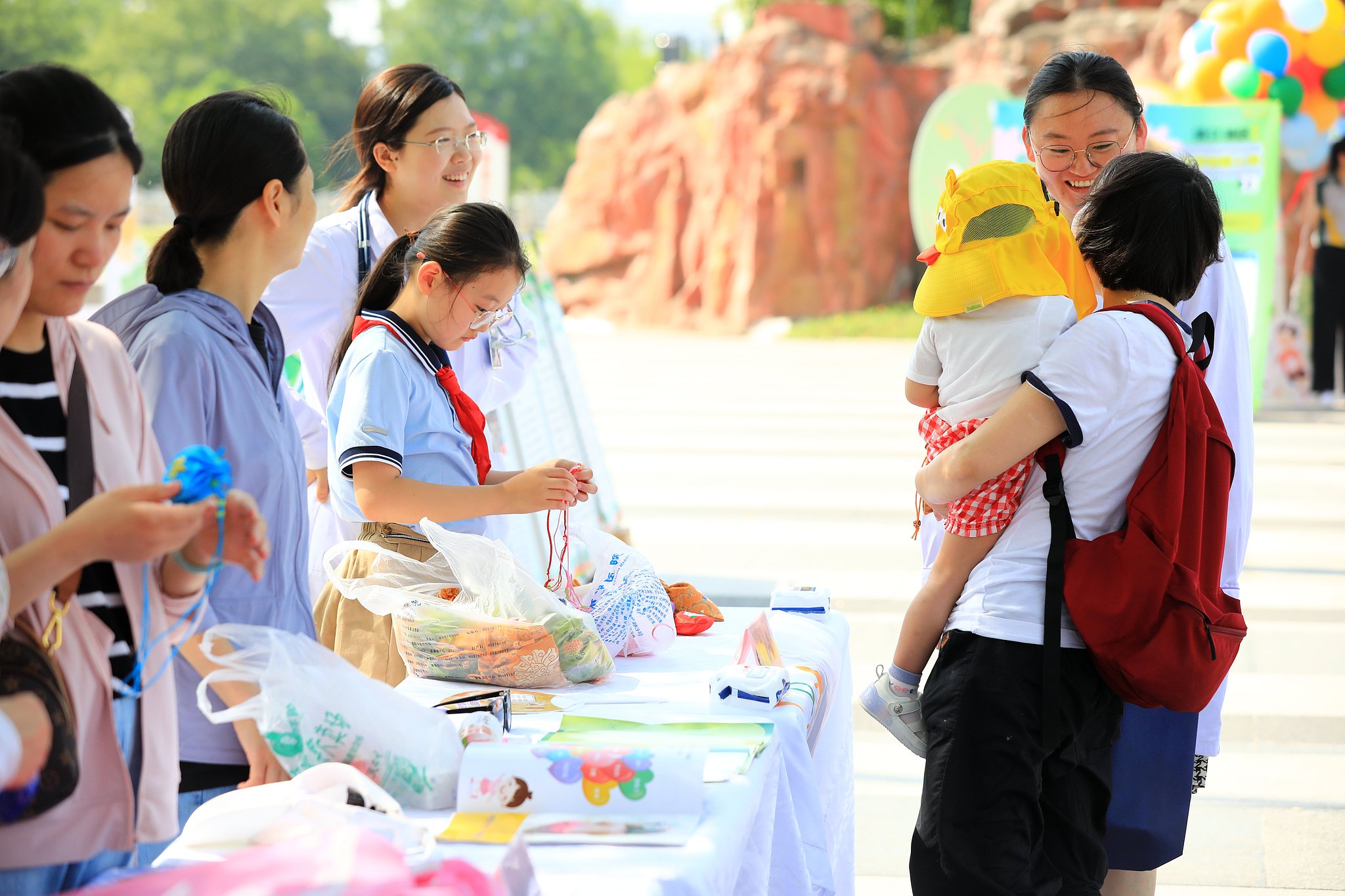 Parents participate in a promotion activity aimed at raising awareness of childcare service policies, benefits, and parenting knowledge in Huai'an City, east China's Jiangsu Province, June 23, 2024. /CFP