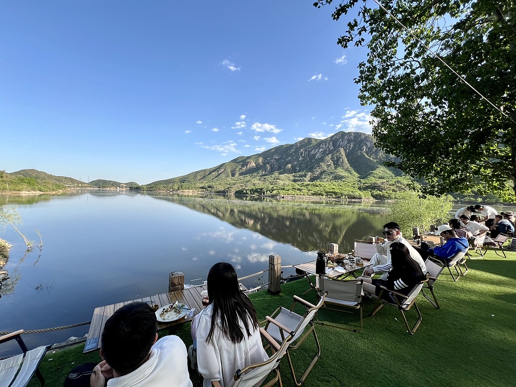 Tourists enjoy coffee at a lakeside cafe in Huairou District, Beijing, capital of China, April 30, 2024. /CFP