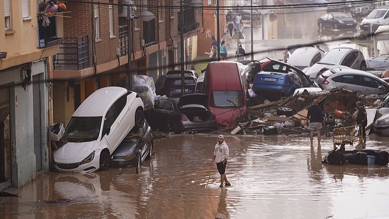 Residents look at cars piled up after being swept away by floods in Valencia, Spain, October 30, 2024. /CFP