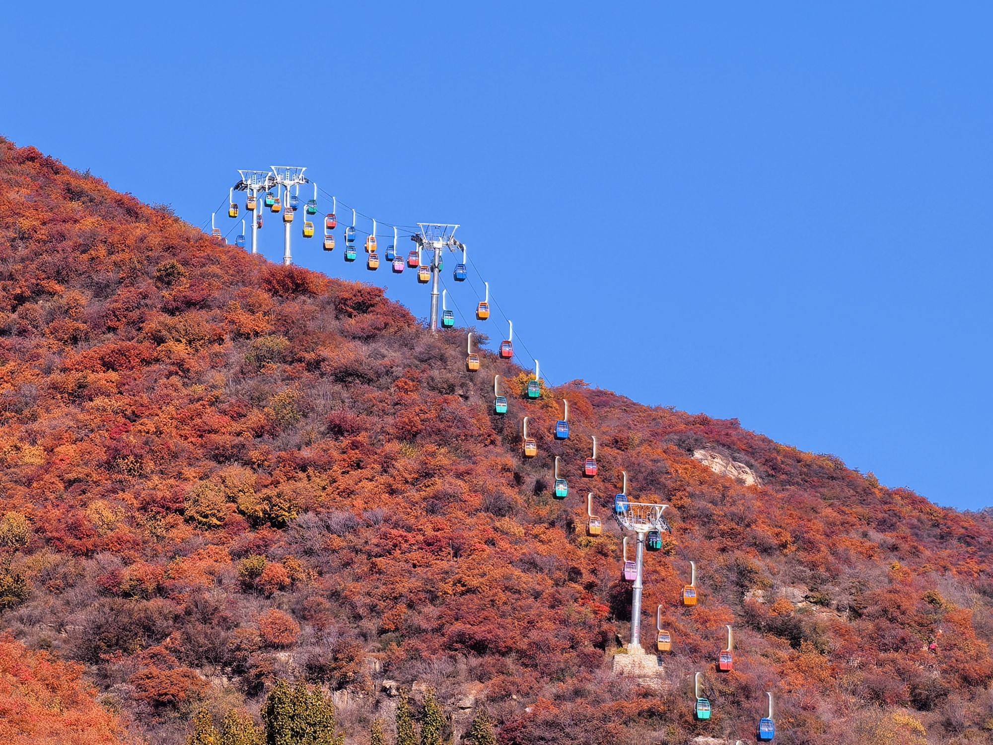 People take cable cars for sightseeing at the Pofengling scenic area in suburban Beijing, capital of China, on October 28, 2024. /CGTN