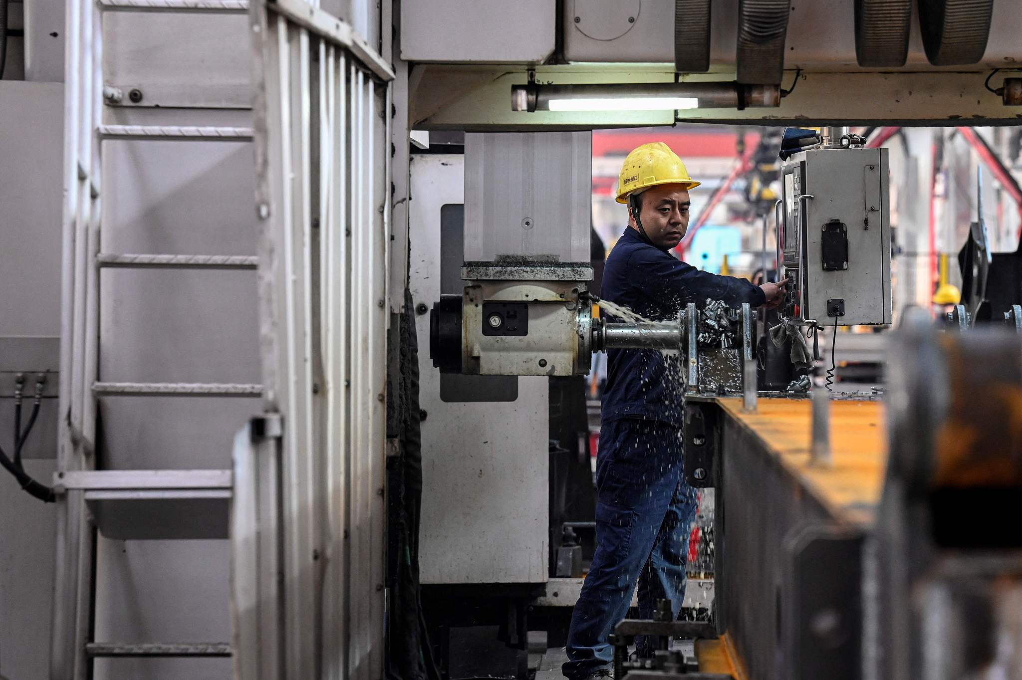 An employee works on a machine production line at a factory in Beijing, October 15, 2021. /CFP
