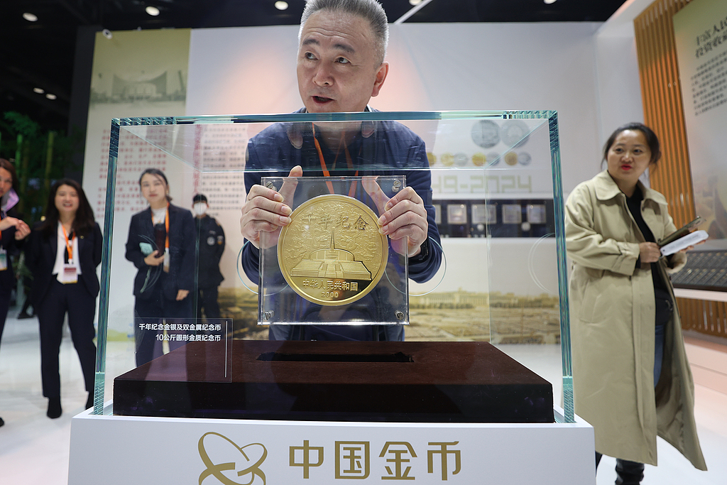  A man holds a 10-kg gold coin at the Beijing International Coin Exposition on November 1, 2024. /CFP