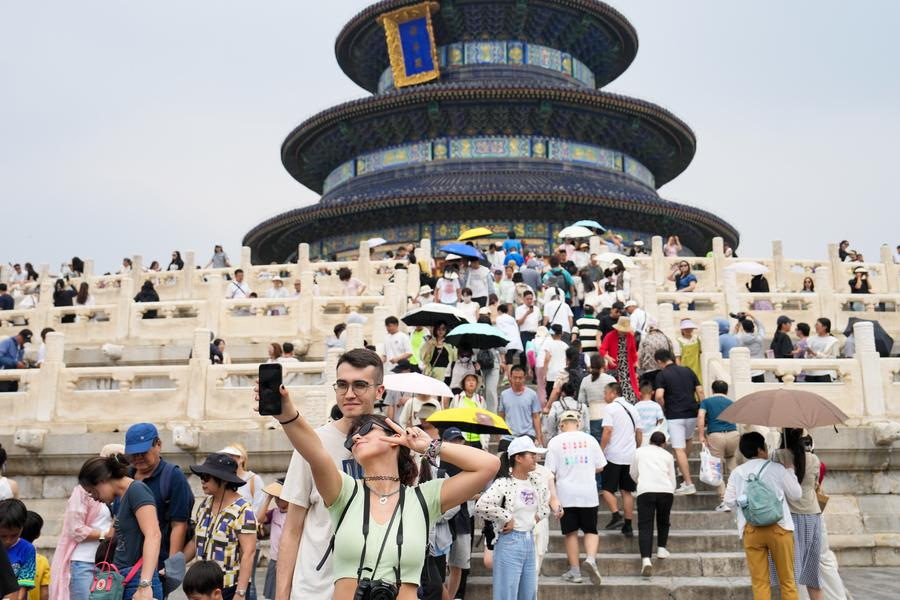 Foreign tourists pose for a photo in front of the Hall of Prayer for Good Harvests, or Qiniandian, at the Tiantan (Temple of Heaven) Park in Beijing, capital of China, July 9, 2024. /Xinhua