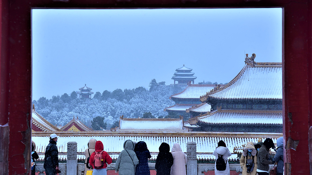 A file photo shows people enjoying the snow during Lidong at the Forbidden City in Beijing, China. /CFP