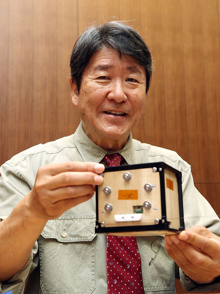 Takao Doi, an astronaut and special professor at Kyoto University, holds the world's first wooden satellite, named LignoSat, during a press conference at the university's campus in Kyoto, May 28, 2024. /CFP