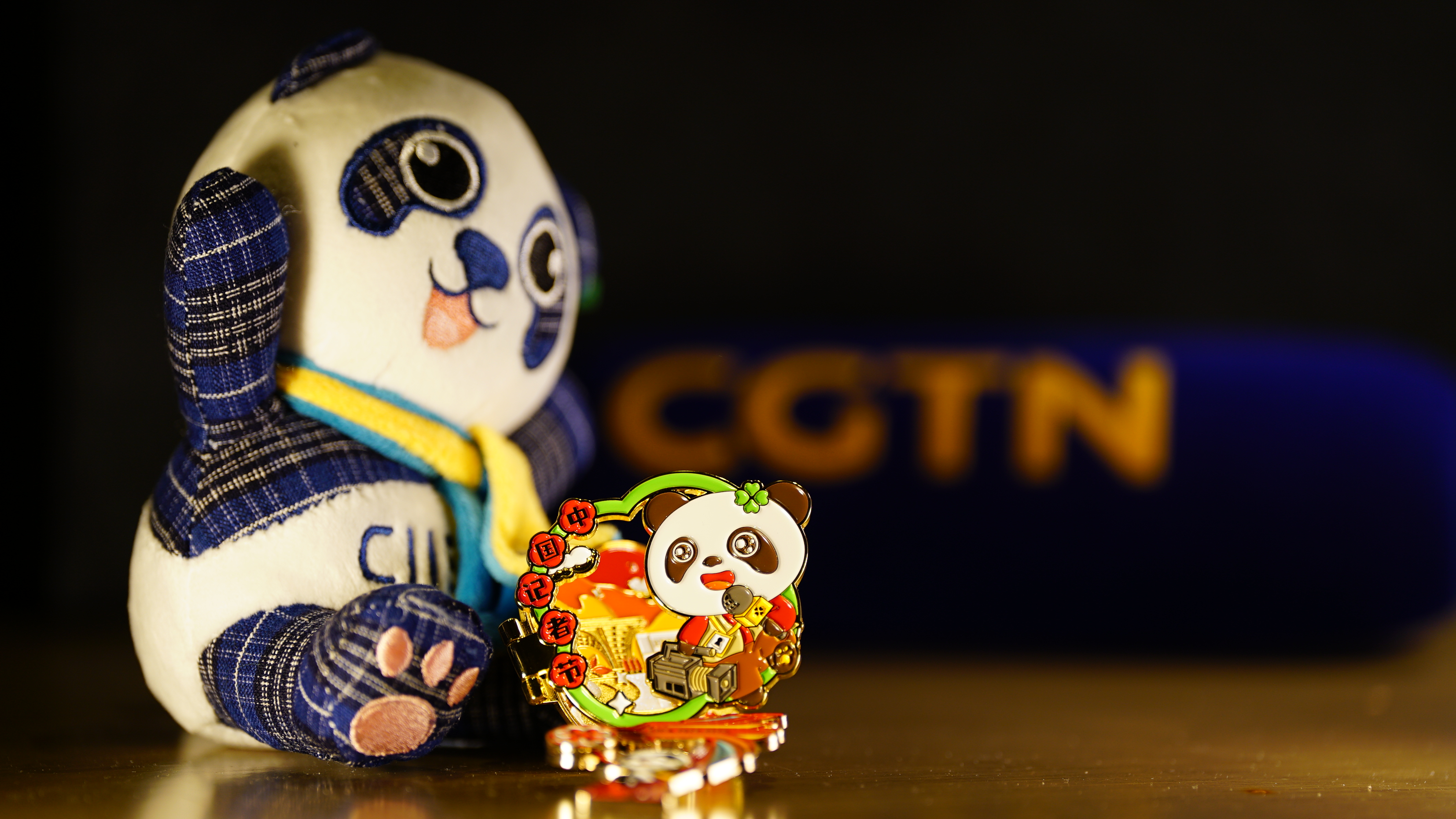 A pin and a stuffed toy featuring Jinbao the panda, the CIIE mascot. /CGTN