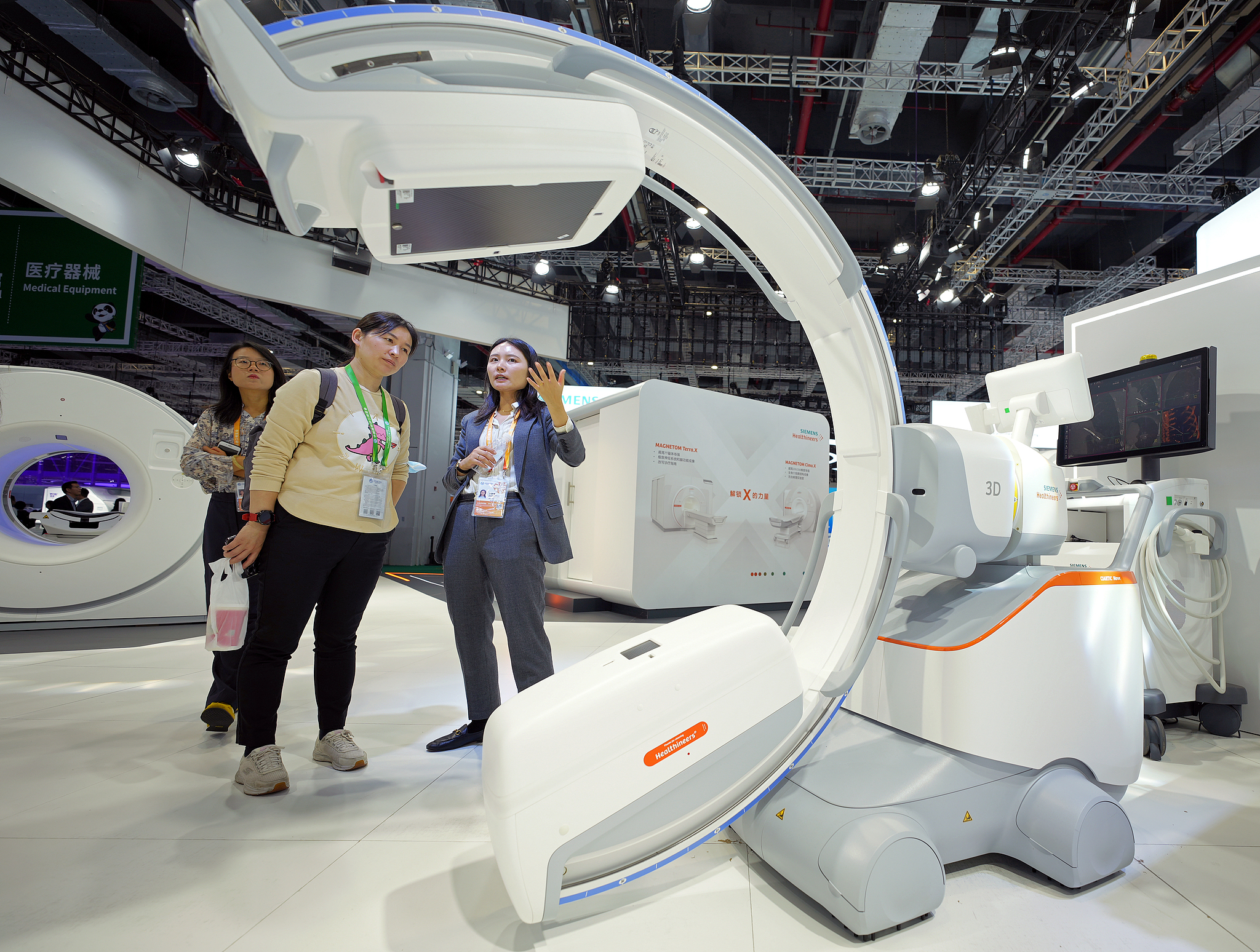 Visitors explore Siemens Healthineers' booth at the seventh CIIE, featuring the Asia debut of the world's first self-driving mobile 3D C-arm 