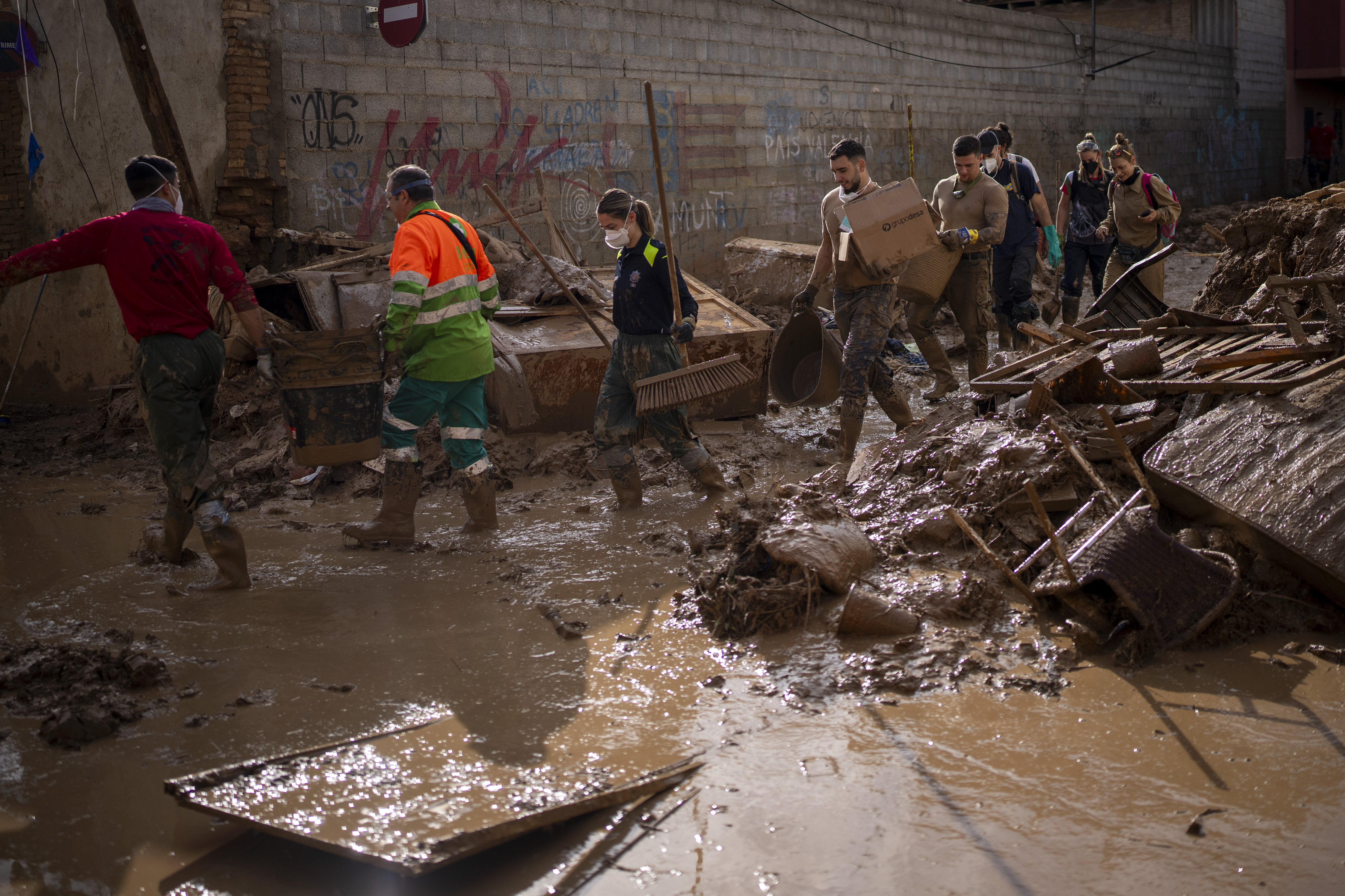 Members of the army and police walk through streets still awash with mud while clearing debris and cleaning up after the floods in Masanasa, Valencia, Spain, November 7, 2024. /AP