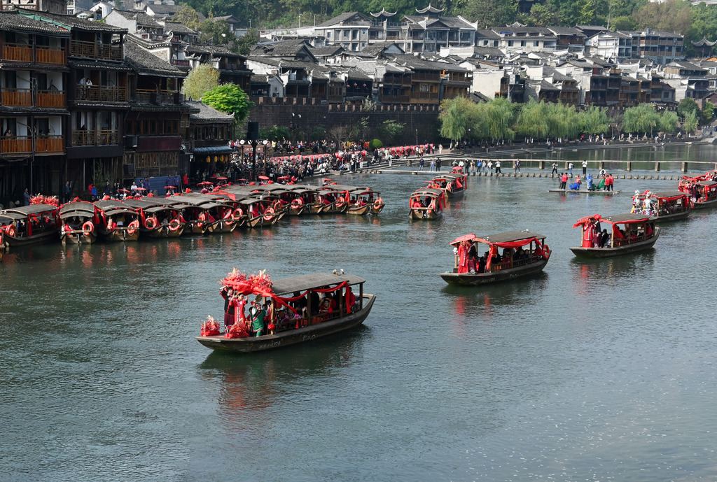 A total of 100 newlywed couples dressed in ethnic wedding attire attend a collective wedding celebration in an ancient town in Fenghuang County of Xiangxi Tujia and Miao Autonomous Prefecture, Hunan Province, November 11, 2024. /CFP  