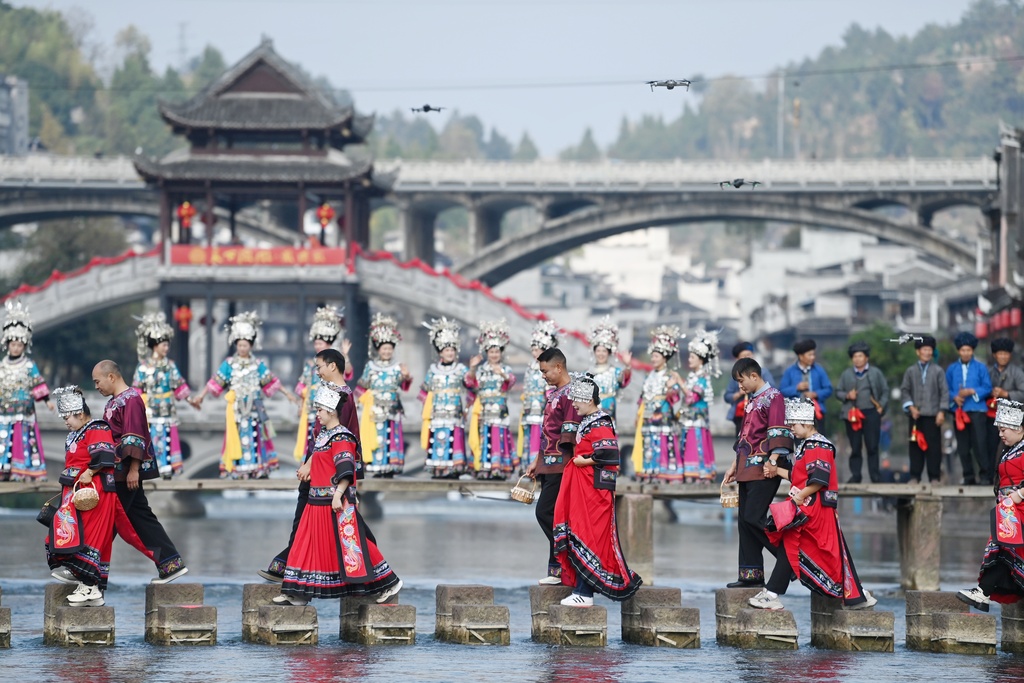 A total of 100 newlywed couples dressed in ethnic wedding attire attend a collective wedding celebration in an ancient town in Fenghuang County of Xiangxi Tujia and Miao Autonomous Prefecture, Hunan Province, November 11, 2024. /CFP  