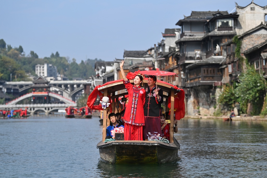 A total of 100 newlywed couples dressed in ethnic wedding attire attend a collective wedding celebration in an ancient town in Fenghuang County of Xiangxi Tujia and Miao Autonomous Prefecture, Hunan Province, November 11, 2024. /CFP  