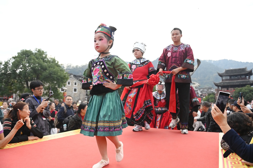 A total of 100 newlywed couples dressed in ethnic wedding attire attend a collective wedding celebration in an ancient town in Fenghuang County of Xiangxi Tujia and Miao Autonomous Prefecture, Hunan Province, November 11, 2024. /CFP  