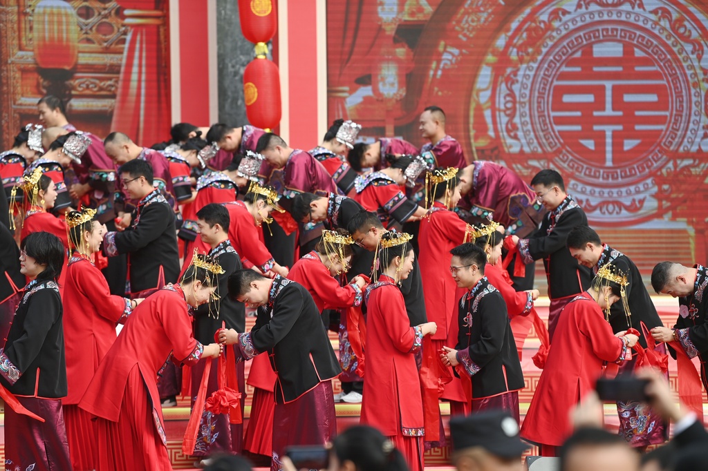 A total of 100 newlywed couples dressed in ethnic wedding attire attend a collective wedding celebration in an ancient town in Fenghuang County of Xiangxi Tujia and Miao Autonomous Prefecture, Hunan Province, November 11, 2024. /CFP  