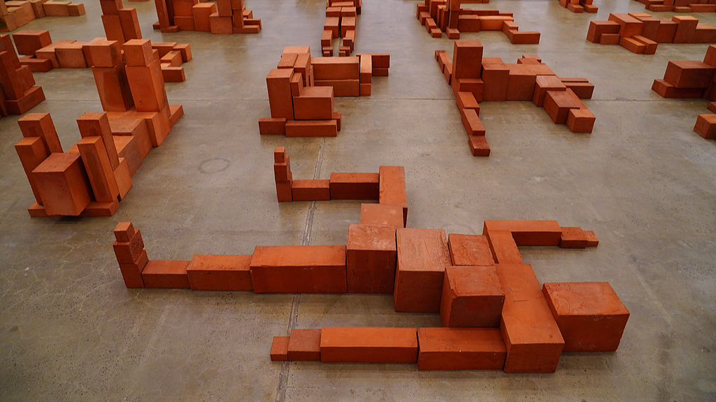 A photo taken on November 19, 2024, shows red clay brick sculptures created by Antony Gormley displayed at the 798 Art District in Beijing, China. /CFP