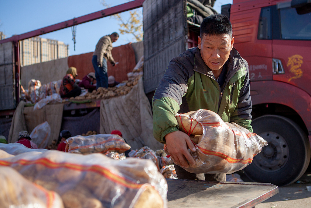 A file photo shows people laying out potatoes on trestles for sale in a street in Taiyuan, Shanxi Province. /CFP