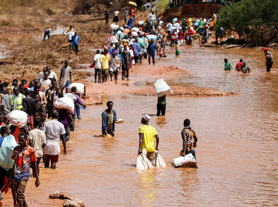 People wade through a flood-destroyed section at the Bangali-Garissa Road in Tana River County, Kenya, December 1, 2023. /Xinhua