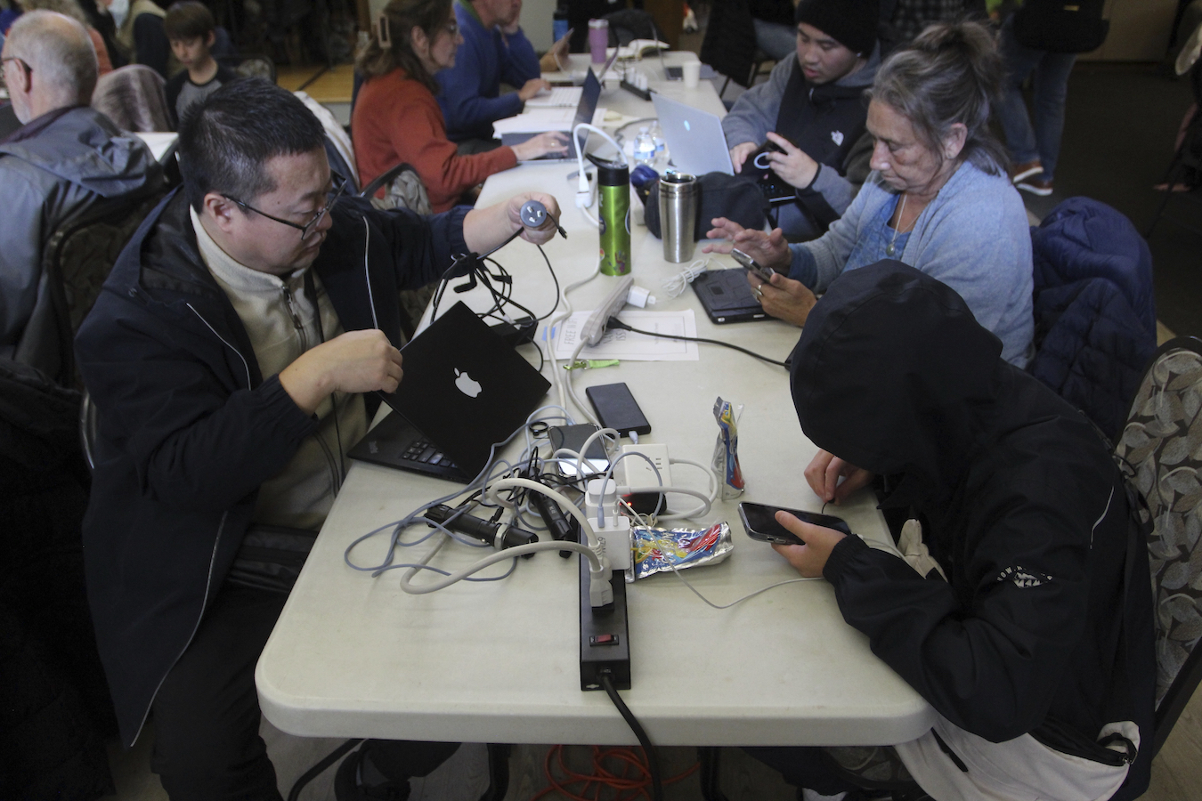 People charge their electronics at a charging station set up at the Issaquah Senior Center in Issaquah, Washington, the U.S., November 22, 2024. /AP