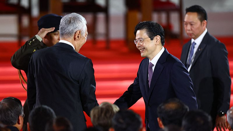 Singapore's new prime minister, Lawrence Wong (R), shakes hands with the former prime minister, Lee Hsien Loong (L), during his swearing-in ceremony at the Istana in Singapore, May 15, 2024. /CFP