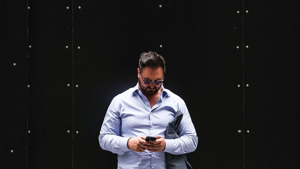 A man uses his phone as he stands on a footpath in central Sydney, Australia, November 7, 2024. /CFP