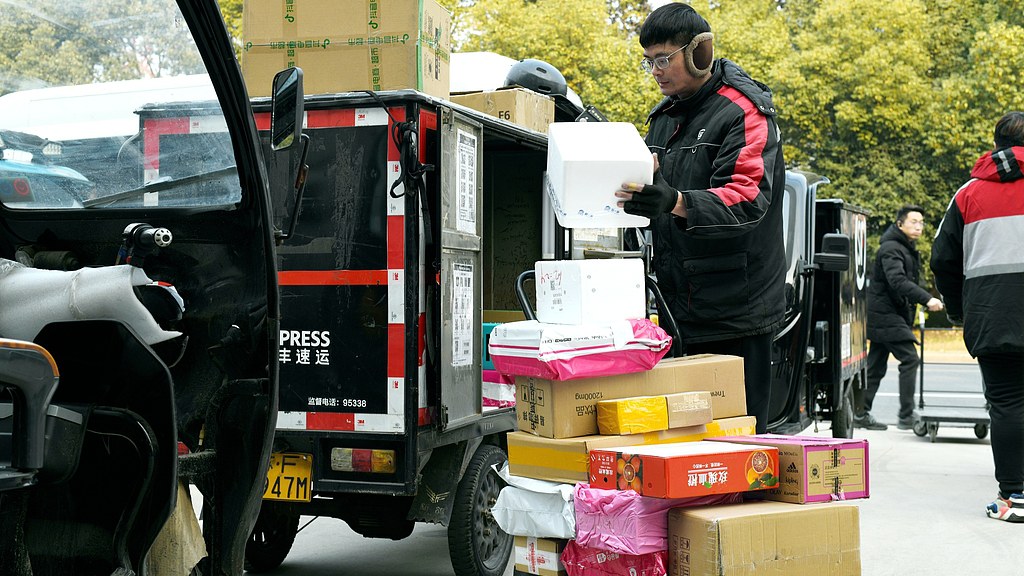 Delivery workers sorting and delivering packages in a local community in Nantong City, east China's Jiangsu Province, February 8, 2024. /CFP