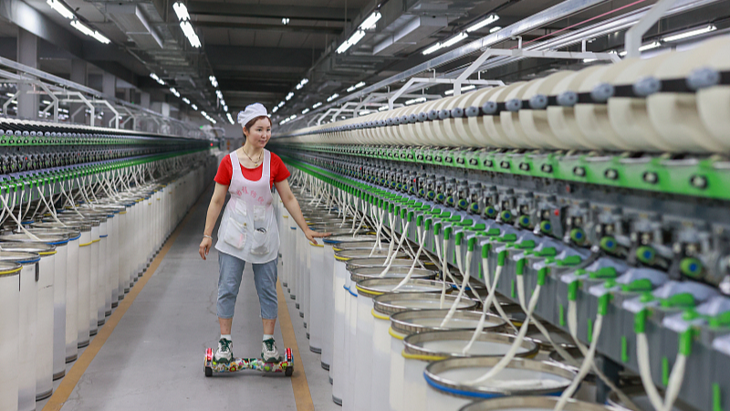 A staff member works while on a hoverboard at a factory in Ili Kazak Autonomous Prefecture, Xinjiang Uygur Autonomous Region, northwest China, September 19, 2023. /CFP