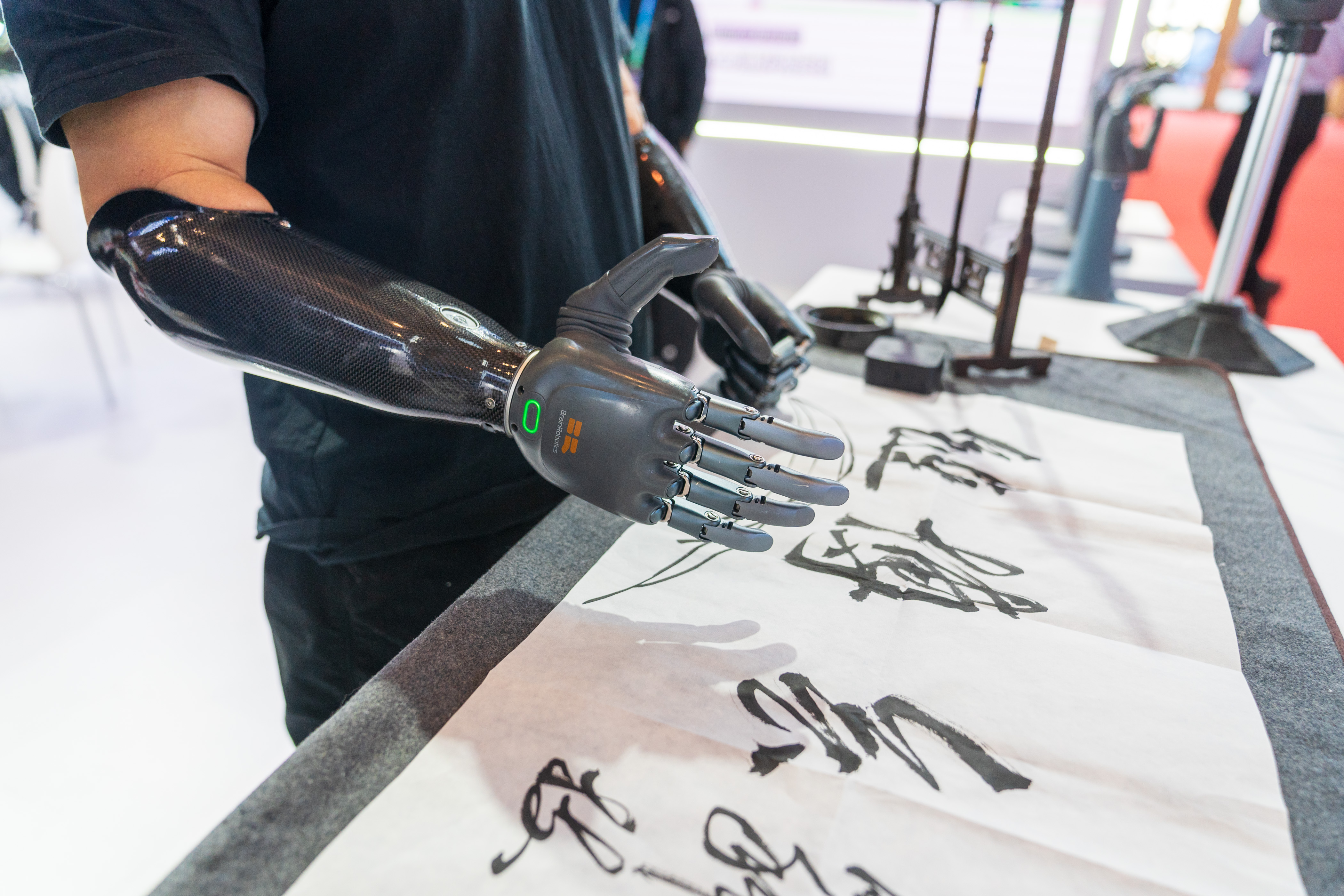 Trying a prosthetic hand to write calligraphy at the Digital Technology Chain exhibition area, November 26, 2024. 