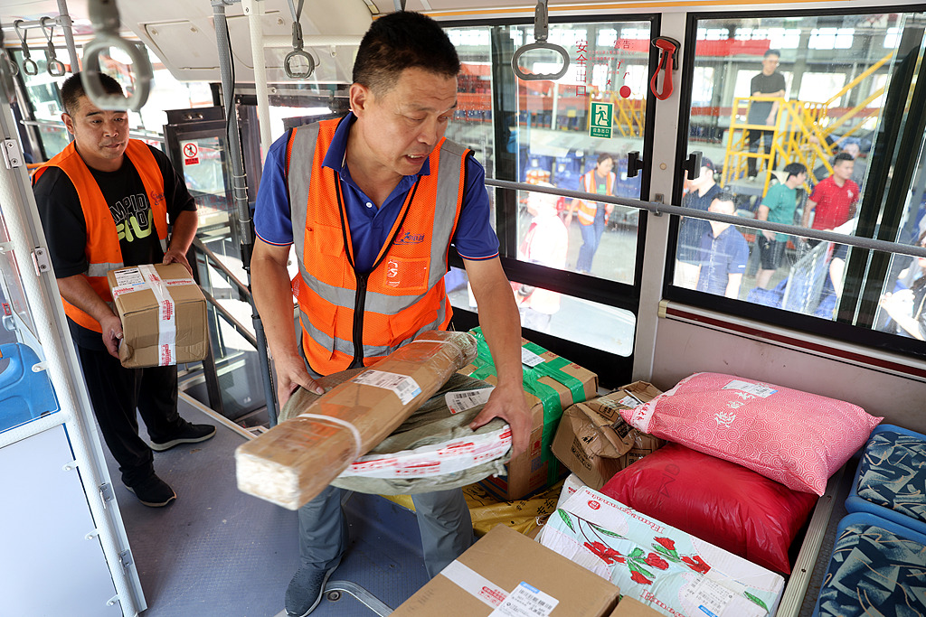 Express delivery workers place packages in a storage area of a bus bound for the countryside in Shandong Province, China, August 30, 2023. /CFP