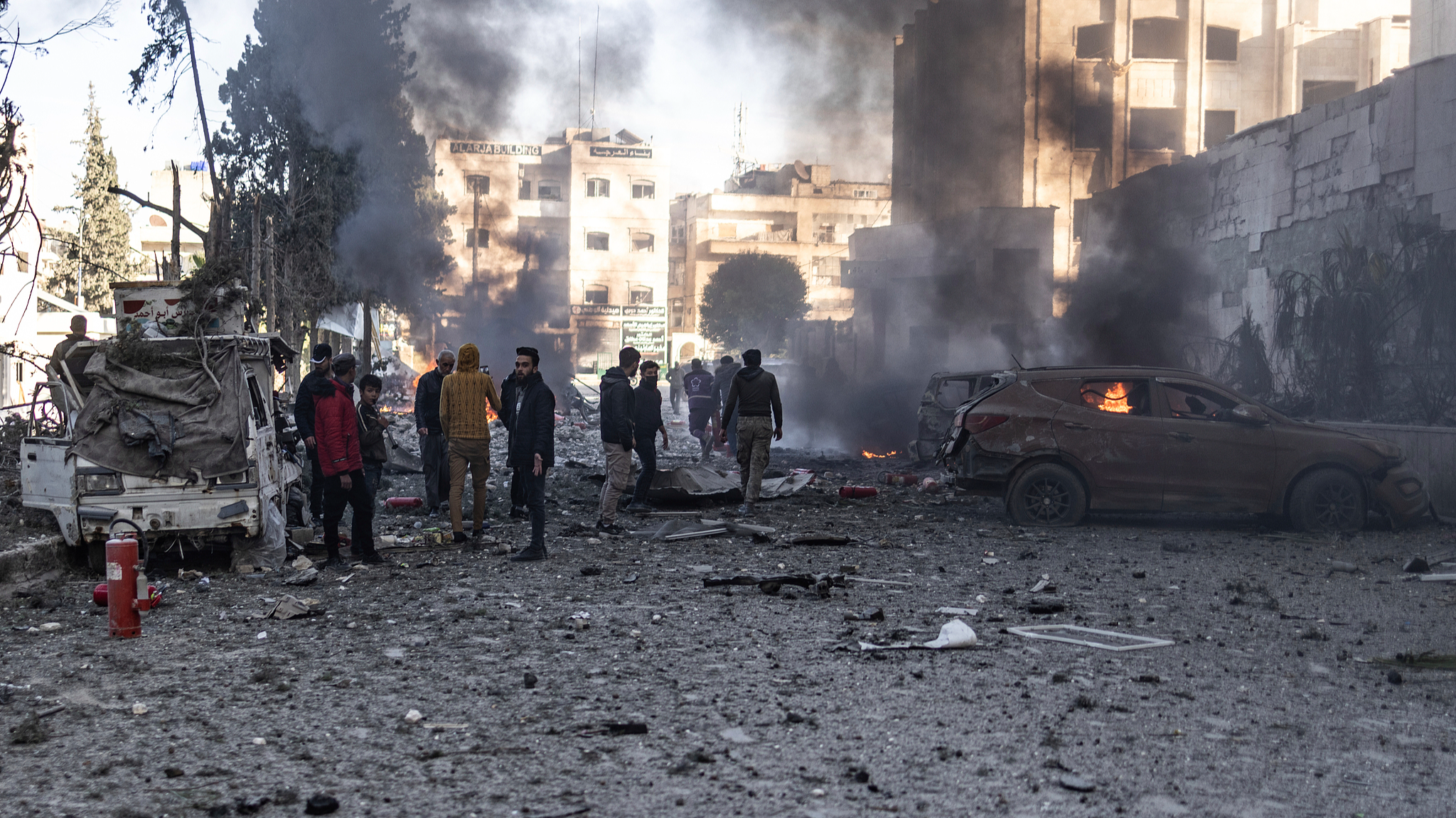 Vehicles burn while people inspect the damage in Idlib, Syria, December 2, 2024. /CFP