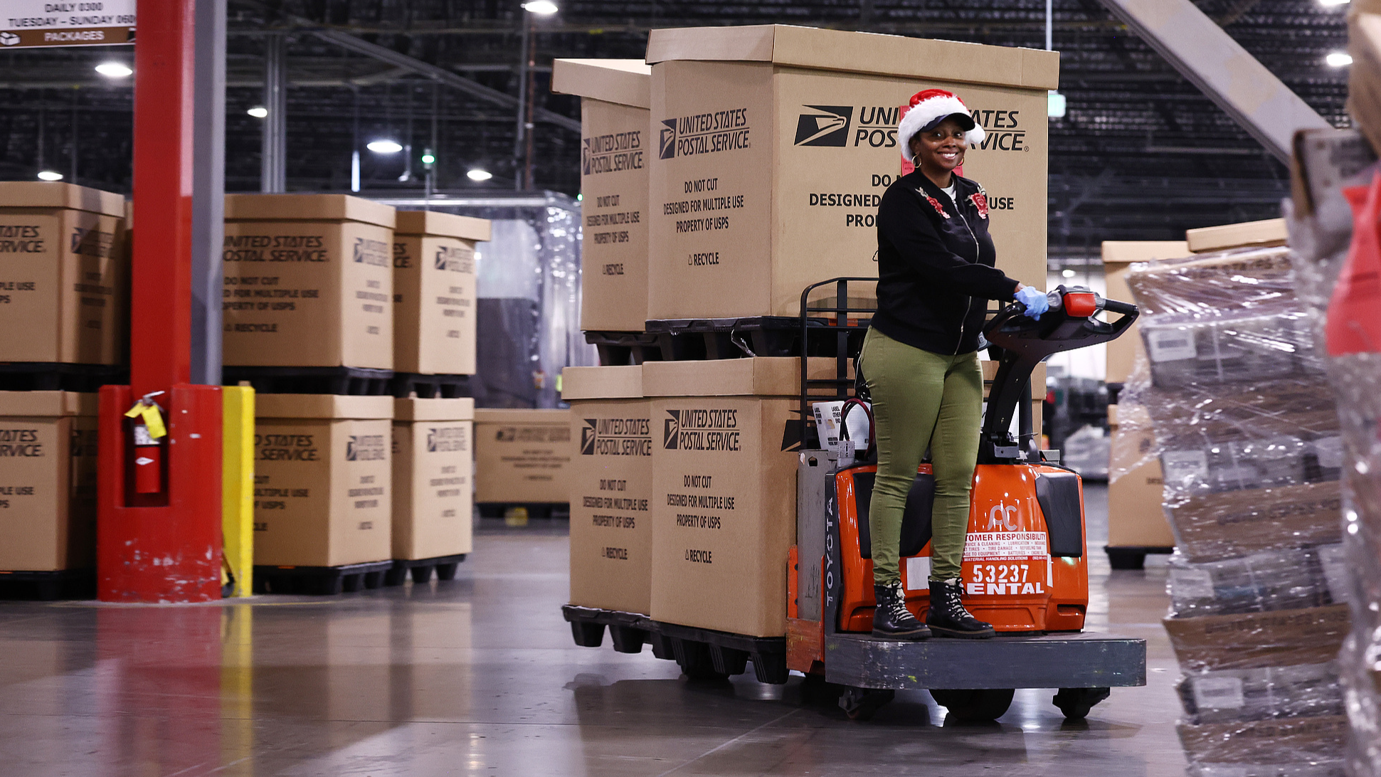 A US Postal Service employee transports parcels for distribution during the start of the holiday mail rush, following Black Friday and Cyber Monday, Los Angeles, California, Dec. 3. /Photo by Mario Tama /Getty Images