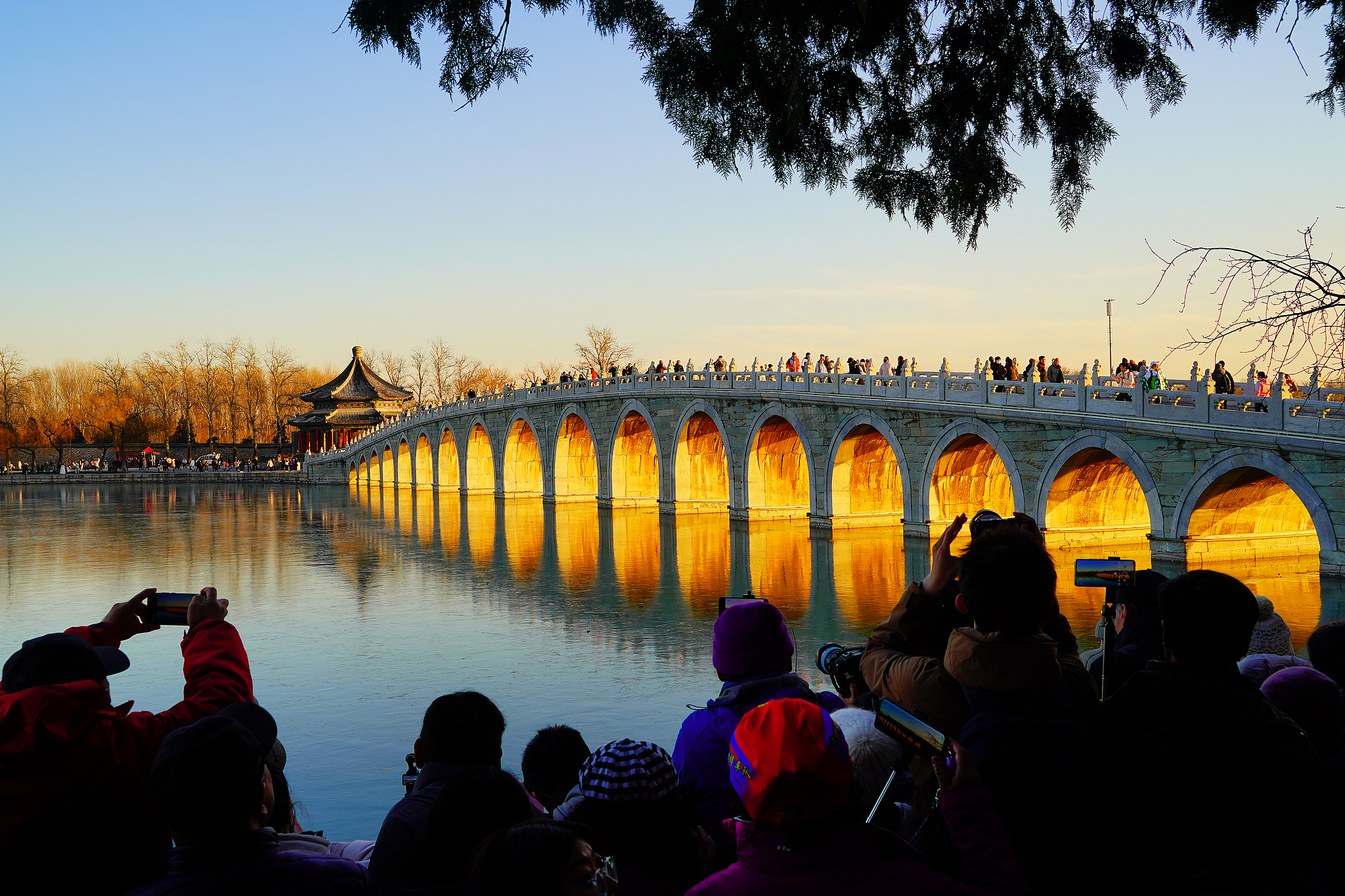 Golden sunlight brightens up the arches of the Seventeen Arch Bridge at the Summer Palace, Beijing, December 9, 2024. /CFP
