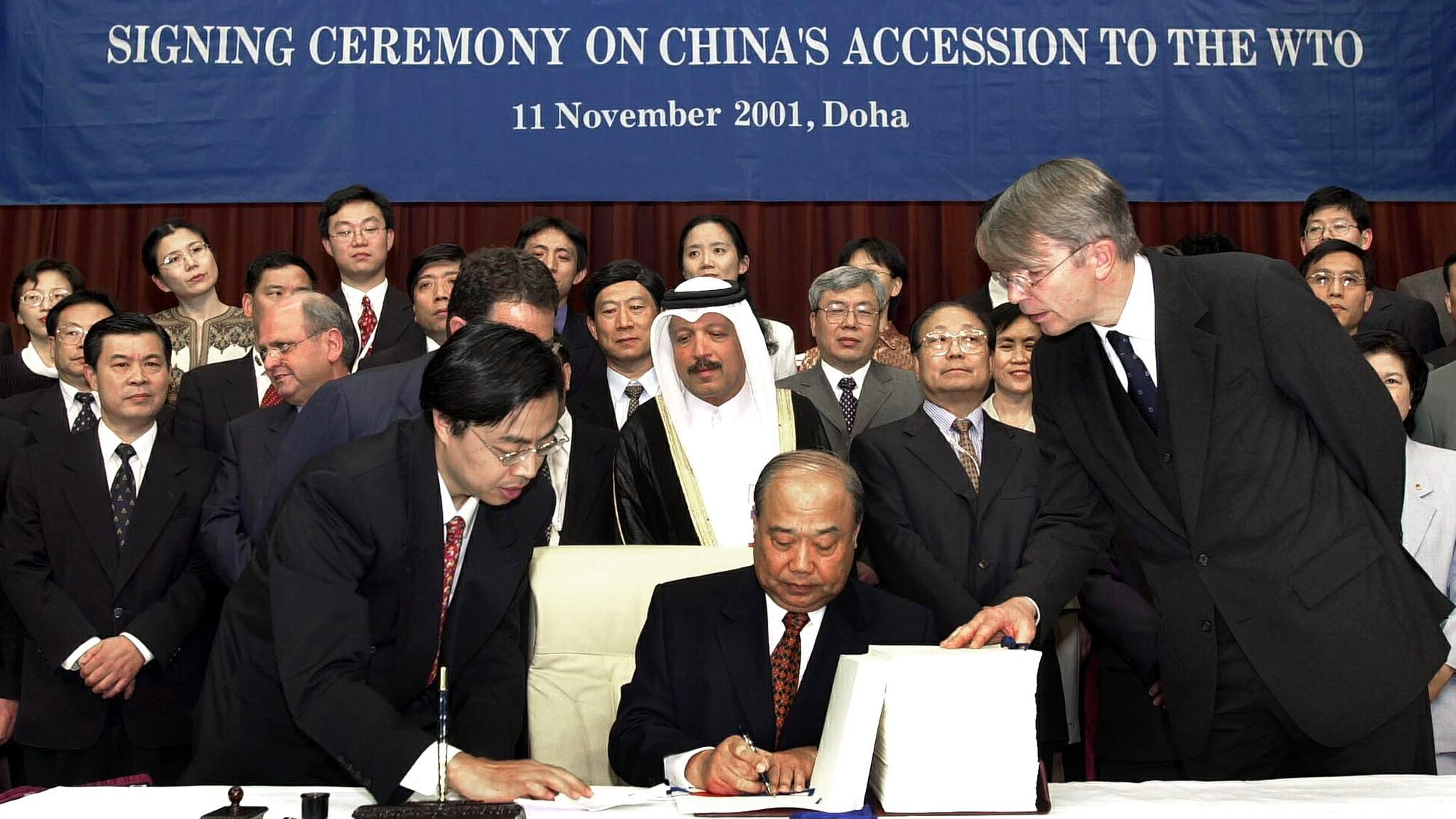 Chinese Minister of Foreign Trade and Economic Cooperation Shi Guangsheng signs documents at the accession ceremony for China to join the World Trade Organization in Doha, December 11, 2001. /CFP