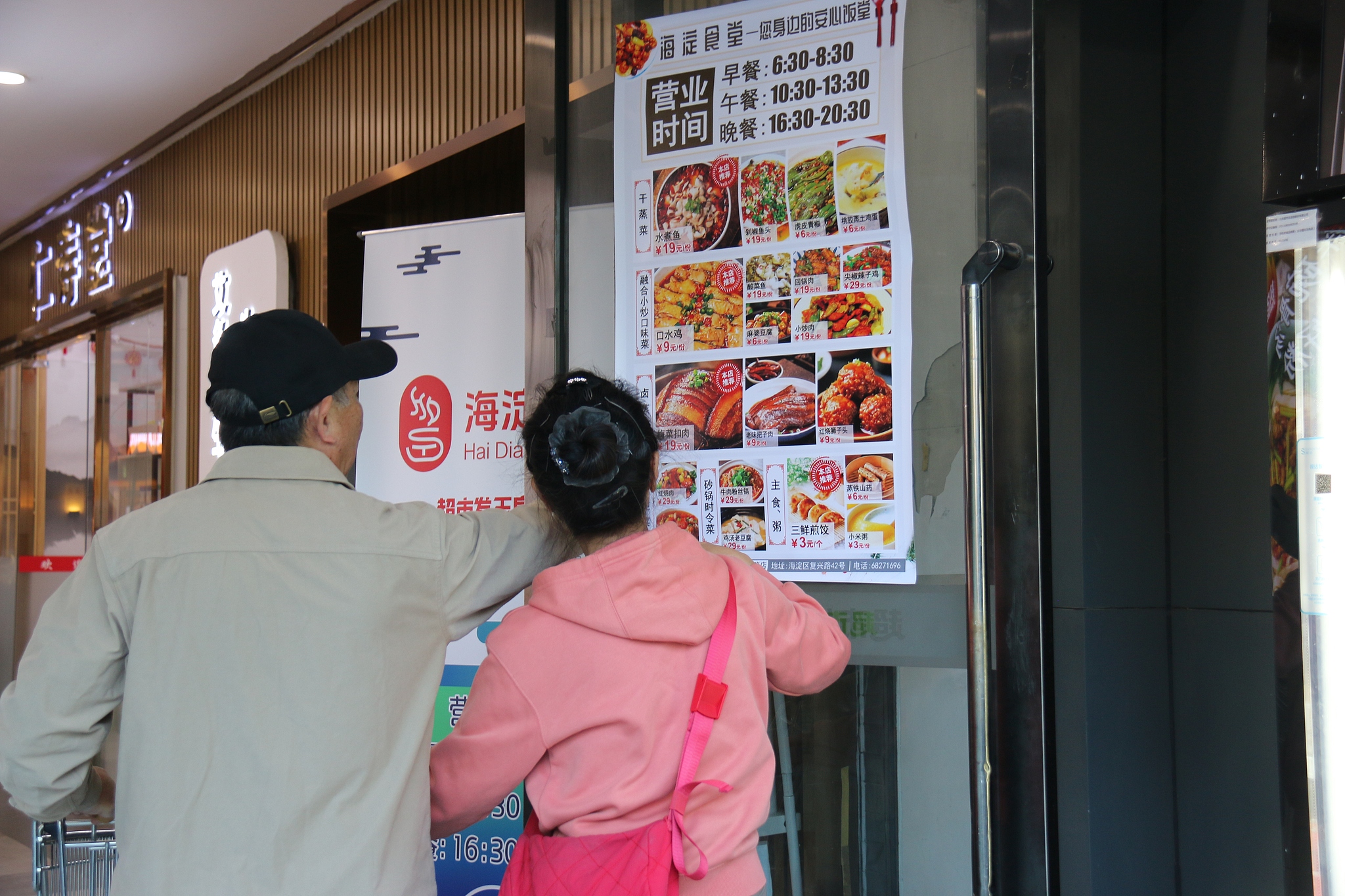 An elderly couple reads the menu at a community canteen in Haidian District, Beijing, October 10, 2024. /CFP