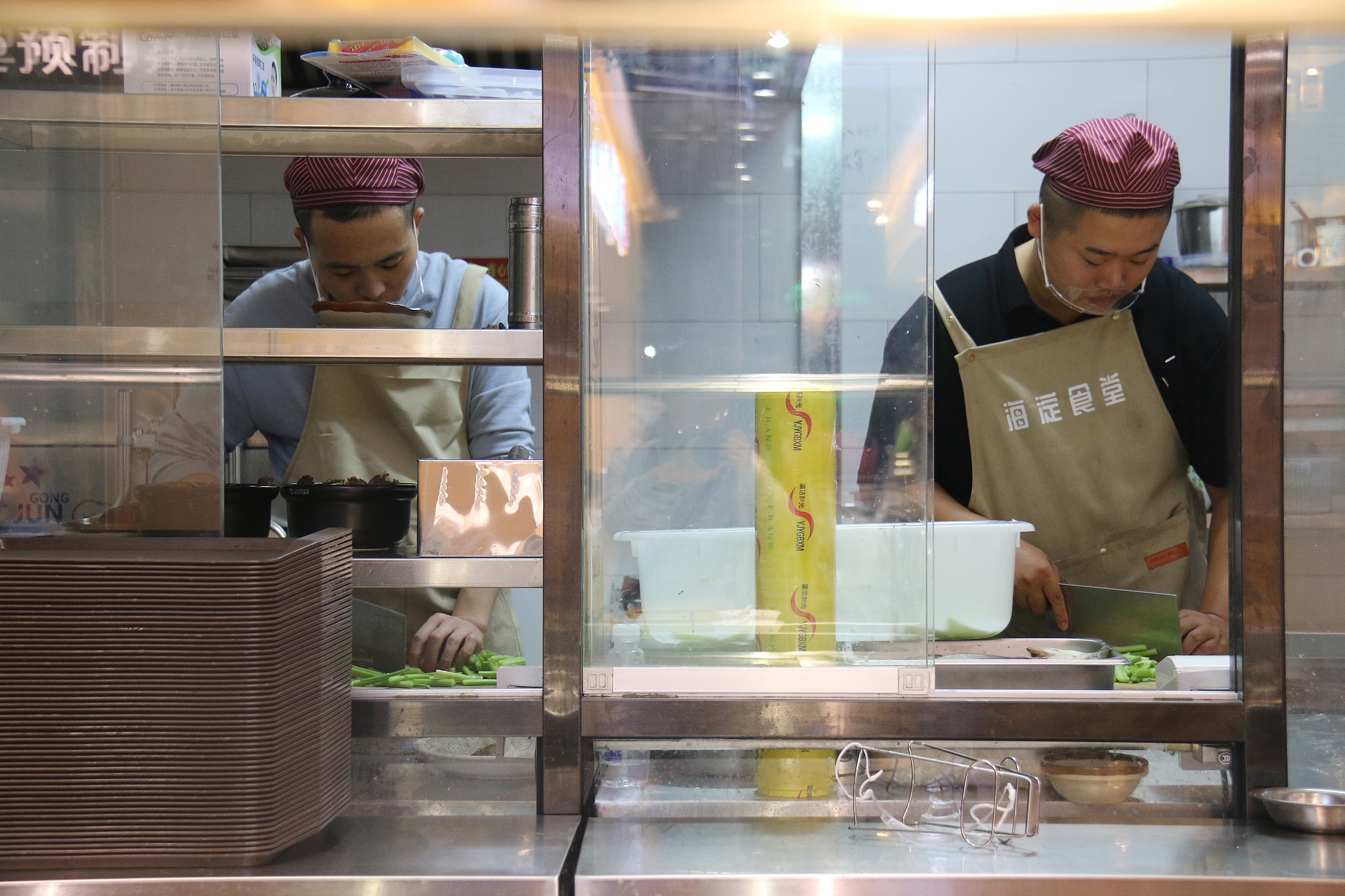 Cooks prepare food at a community canteen in Haidian District, Beijing, October 10, 2024. /CFP