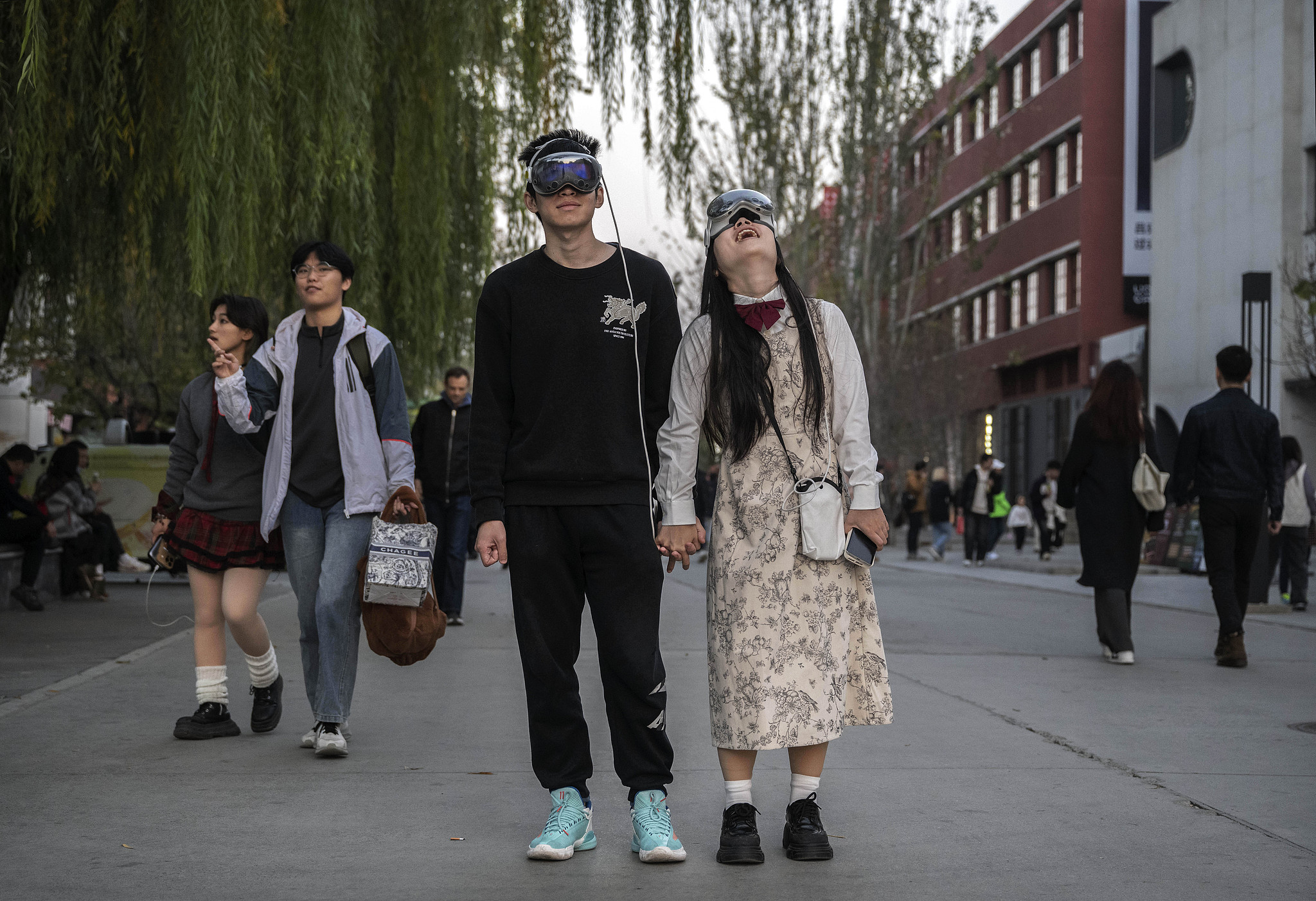 A couple wear VR headsets as they walk in the 798 Art District in Beijing, November 10, 2024. /Getty