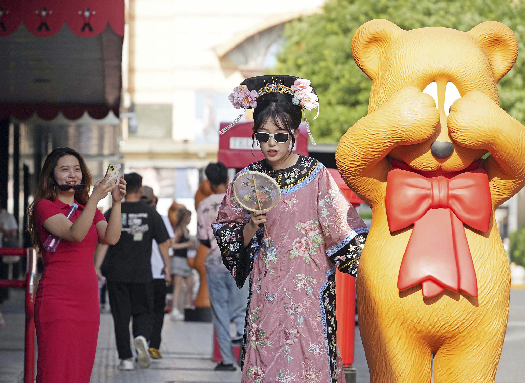 A woman dressed in hanfu takes photos with an animal figure in Beijing, June 26, 2024. /CFP