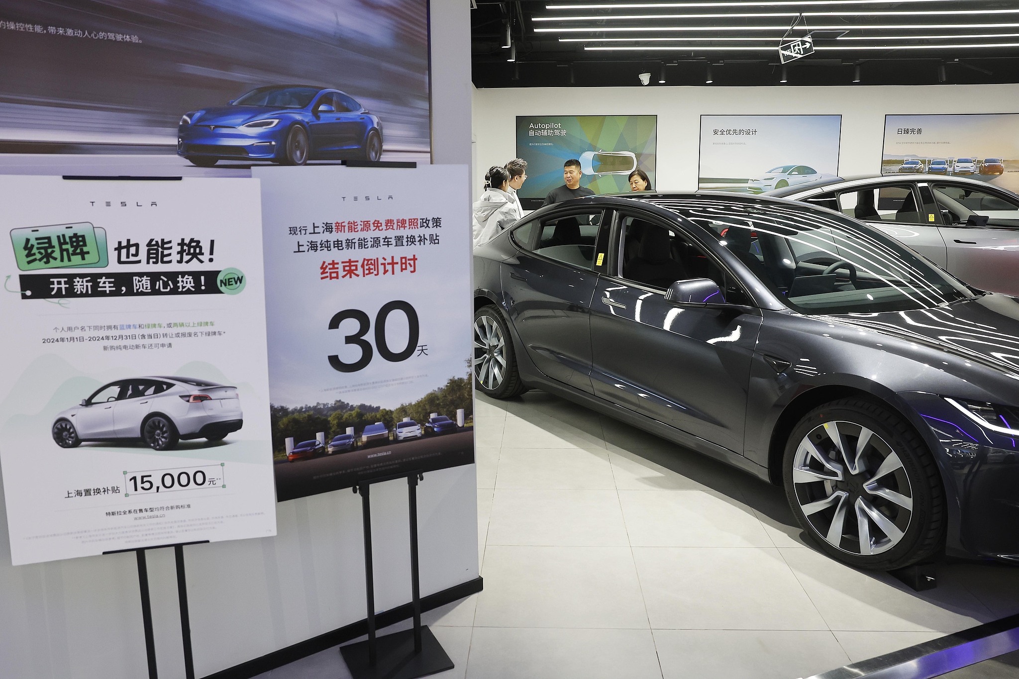 Consumers at a new energy vehicle section of a shopping center in Shanghai, learning about new energy cars on December 1, 2024. /CFP