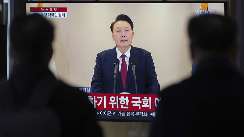 People watch a TV screen showing the live broadcast of South Korean President Yoon Suk-yeol's announcement at the Seoul Railway Station in Seoul, South Korea, December 12, 2024. /CFP